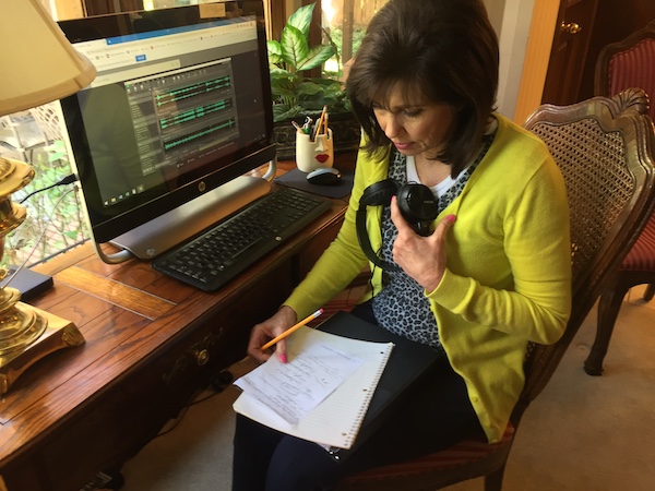 Author Barbra Ausere Wood sits at a computer and works on the songs for the eBook I Can Spell My Colors.