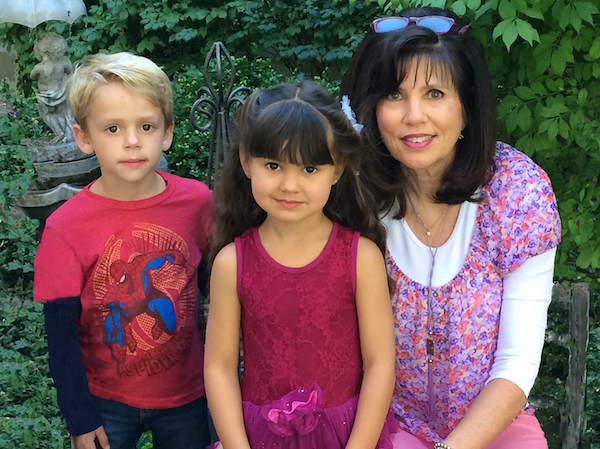 Author Barbra Ausere Wood sits with 2 young kids outside